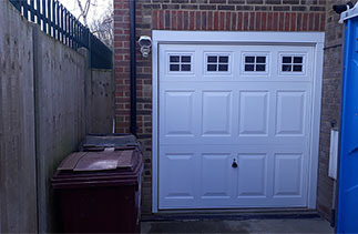 A Garador Beaumont with windows steel up and over garage door. With a white timber frame and white PVC cladding. Door fitted near Reading, Berkshire.
