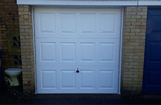 A Garador Georgian style up and over steel garage door with a white steel frame. Fitted in Sandhurst. Berkshire.