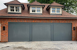 Three bespoke Woodrite Accoya timber up and over garage doors. With Matching cladding. Fitted in Jordans, Buckingham.