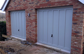 Two Woodriet Somerset range Churchill style up and over garage doors. In a Farrow and Ball colour match with white steel frames. Fitted near Farnham. Surrey.