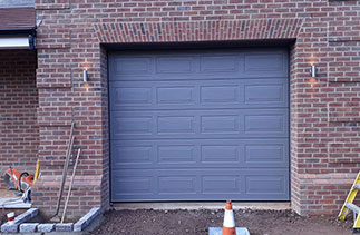 A Carteck 40mm insulated sectional garage door. In the Georgian style. In a colour match to Farrow and Ball Moles Breath. Fitted in Virginia Water. Surrey.