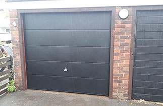 A Garador steel range up and over garage door in the Ascot Style. In Black with a black steel frame. Fitted behind the existing timber frame. Fitted in Weybridge. In Surrey.