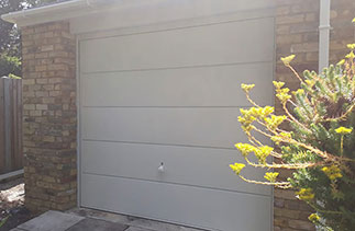 A Garador steel range up and over garage door in the Ascot Style. In White with a White steel frame and a White handle. Fitted in Camberley. Surrey.
