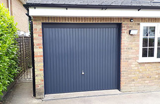 A Garador steel range up and over garage door in the Carlton style. In Anthracite Grey with a Anthracite Grey steel frame and a Chrome effect handle. Fitted in Camberley. Surrey.