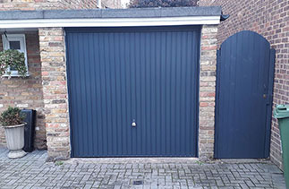 A Garador steel range up and over garage door in the Carlton style. In Anthracite Grey with a matching steel frame and a Chrome effect handle. Fitted in Windlesham. Surrey.