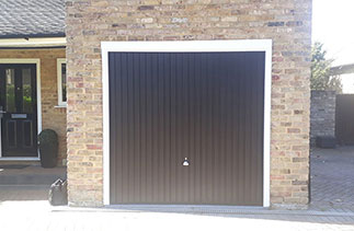 A Garador steel range up and over garage door in the Carlton style. In Black with a White steel frame. With a Chrome effect handle. Fitted in Camberley. Surrey.
