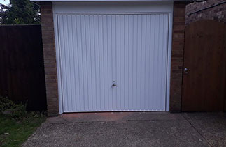 A Garador steel range up and over garage door in the Carlton style. In White with a White steel frame and a Chrome effect handle. Fitted in Yatley. Hampshire.
