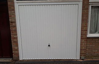 A Garador steel range up and over garage door in the Carlton style. In White with a White steel frame. Fitted in Windlesham. Surrey.