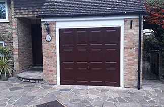 A Garador steel range up and over garage door in the Georgian style. In Burgundy Brown with a white steel frame. Fitted in Camberley. Surrey.