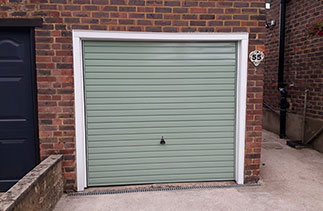 A Garador steel range up and over garage door in the Horizon style. In Chartwell Green with a White steel frame and White pvc on the existing timber frame. Fitted near Aldershot. Hampshire.