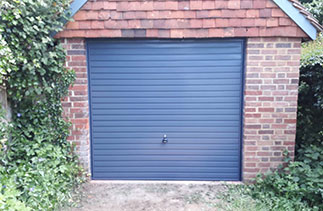 A Garador steel range up and over garage door in the Horizon style. In Slate Grey with matching steel frame. Fitted in Godalming. Surrey.