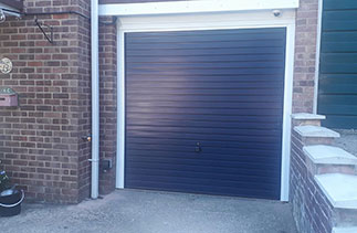 A Garador steel range up and over garage door in the Horizon style. In steel Blue colour with a White steel frame. Fitted in Sandhurst. Berkshire.