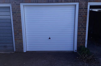 A Garador steel range up and over garage door in the Horizon style. In White with a White steel frame and With White pvc to cover the existing timber frame. Fitted in Guildford. Surrey.