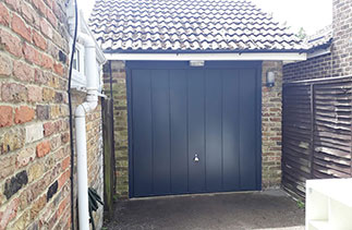 A Garador steel range up and over garage door. In the Windsor style. In Anthracite Grey with a matching steel frame and a Chrome effect handle. Fitted in Lightwater. Surrey.