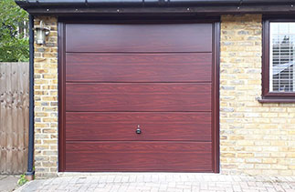 A Garador steel range up and over garage in the Wentwood  design. In Rosewood with a Burgundy Brown steel frame and with Rosewood pvc. Fitted in Camberley. Surrey.