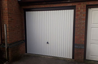 A Garador steel up and over garage door in the Carlton style in White. With a Burgundy Brown steel frame with Rosewood pvc. Fitted in Guildford. Surrey.