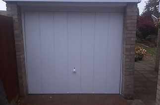 A Garador steel up and over garage door in the Windsor style. With a white steel frame. Fitted in Frimley. Surrey.
