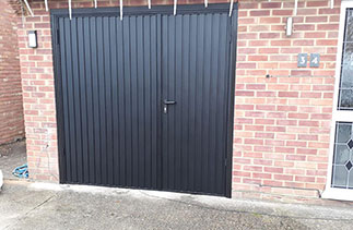 A set of Garador steel side hinged garage doors. In a 2/3rd x 1/3rd split. In Black with a Black steel frame. Fitted in Mytchet. Surrey