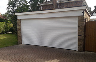 A Sws Seceuroglide Excel Insulated Roller Shutter Garage Door in White. Fitted in Camberley, Surrey. This garage used to be two single doors and we removed the centre brick pier and installed a steel RSJ.