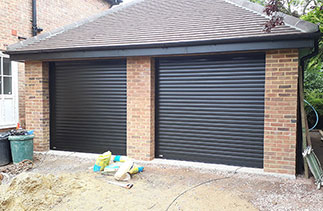 Two Sws Seceuroglide Excel Insulated Roller Shutter Garage Doors in Black Wood Grain. Fitted in Guildford, Surrey.