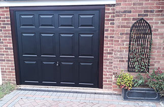 A Garador steel range up and over garage door in the Beaumont style. In Black with a Black steel frame. With Rosewood pvc. Fitted in  Yatley. Hampshire.