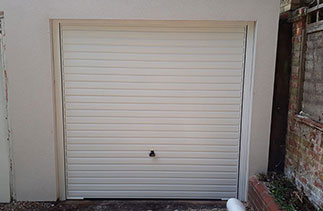 A Garador steel range up and over garage door in the Horizon style. In White with a White steel frame. Fitted in Woking. Surrey.