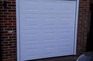 A Hormann 40mm insulated sectional garage door. In the Georgian style. In White wood grain textured finish. The Georgian style is only available in a wood grain textured finish. Fitted in Guildford. Surrey.