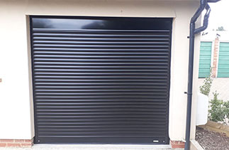 A Sws Seceuroglide compact roller shutter garage door. In Black with matching guides and a matching full box. Fitted in Woking. Surrey.