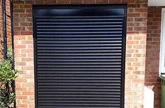 A Sws Seceuroglide compact roller shutter garage door. In Black with matching guides and a matching full box. Fitted in Woking. Surrey.