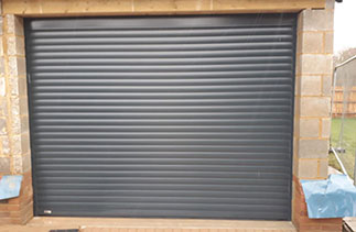 A Sws Seceuroglide Excel roller shutter garage door in Anthracite Grey. With matching guides and a matching full box. This door is one of Eight fitted on the same site of new houses. Fitted in Banstead. Surrey.