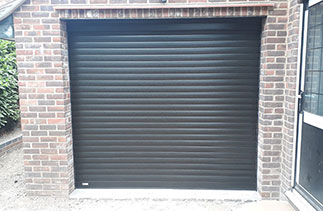 A Sws Seceuroglide Excel roller shutter garage door. In Black wood grain. With matching guides and a matching box. Fitted in Woking. Surrey.