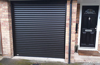 A Sws Seceuroglide Excel roller shutter garage door. In Black wood grain. With matching guides and box. Fitted in Westend. Surrey.
