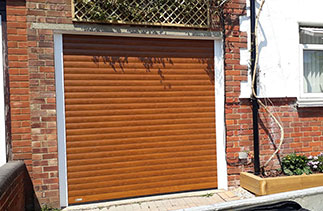 A Sws Seceuroglide Excel roller shutter garage door. In Golden Oak. With White guides and a white full box. Fitted in Camberley. Surrey.