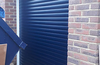 A Sws Seceuroglide Excel roller shutter garage door. In Navy Blue with White guides and a white full box. Fitted in Twickenham. Greater London.