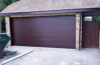 A Sws Seceuroglide Excel roller shutter garage door. In Rosewood. With matching guides and box. Fitted in Hook. Hampshire.