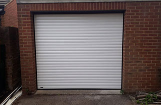 A Sws Seceuroglide Excel roller shutter garage door. In White with Rosewood pvc. Fitted in Mytchet. Surrey.