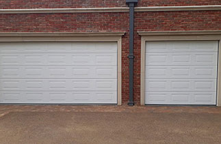 Two Carteck 40mm insulated sectional garage doors. In the Georgian style. In a White wood grain textured finish. Fitted on the Wentworth Estate. Virginia Water. Surrey.