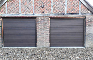Two Carteck 40mm insulated sectional garage doors. In the Standard Rib style. In Night Oak wood finish. Fitted in Wonersh. Near Guildford. Surrey.