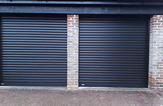 Two Sws Seceuroglide Excel roller shutter garage doors. In Black wood grain with matching guides and a matching boxes. Fitted in Yatley. Hampshire.