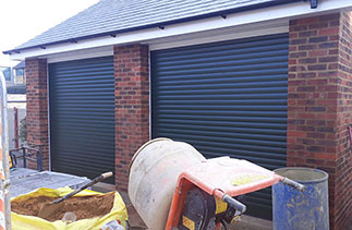 Two Sws Seceuroglide Excel roller shutter garage doors. In Green with White guides and White full boxes. Fitted in Maidenhead. Berkshire.