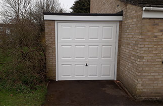 A Garador steel up and over garage door in the Georgian style in White with a white steel frame and a new white Pvc fascia. Fitted in Camberley, Surrey.