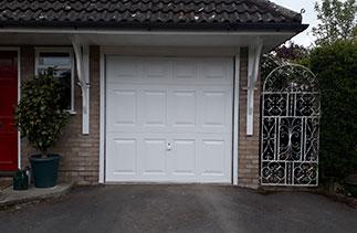 A Garador White Beaumont style up and over garage door. With a white handle. Fitted in Farnham, Surrey.