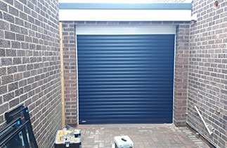 A Navy Blue Sws Seceuroglide Excel roller shutter garage door, with a White Full box and guides. Fitted in Blackwater, Surrey.