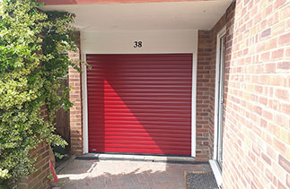A Sws Seceuroglide Excel insulated Roller Shutter Garage Door in Red with a new White PVC Fascia. Fitted in Camberley, Surrey