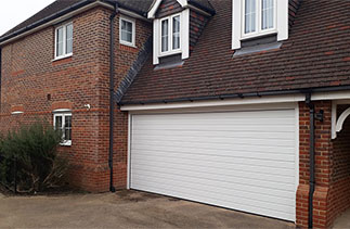 A Carteck 40mm insulated sectional garage door in the Ribbed style, in White. Fitted in Bisley, Surrey.