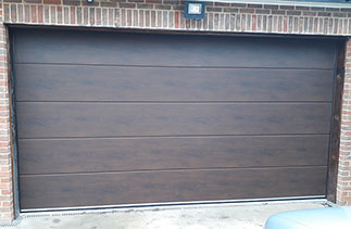 A Carteck 40mm insulated Solid rib sectional garage door in Night Oak. Fitted in East Horsley, Surrey.