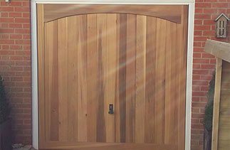 Timber up and over canopy door with a white steel frame fitted in West End, Surrey.