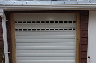A Gliderol manual insulated roller shutter garage door fitted to a bin store with punched and unglazed slats for ventilation