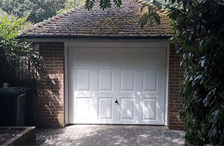 A Garador Beaumont up and over garage door in white with a white steel frame. Fitted in Yatley, Hampshire.