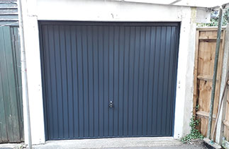A Garador Carlton style steel up and over garage door in Anthracite Grey with a matching frame. Fitted in Camberley, Surrey.